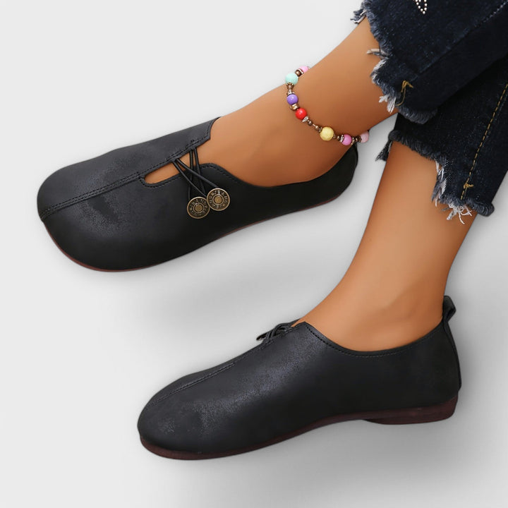 Notburga - Schwarzi Slipper mit Schnüerig