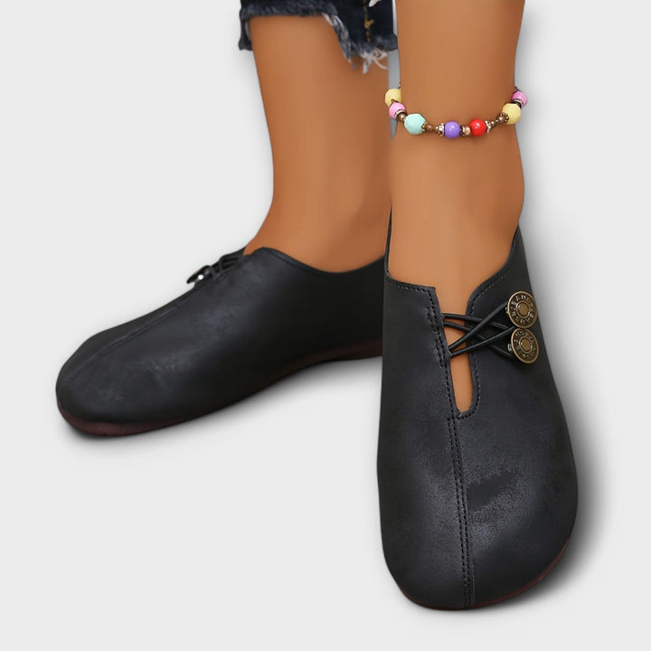 Notburga - Schwarzi Slipper mit Schnüerig